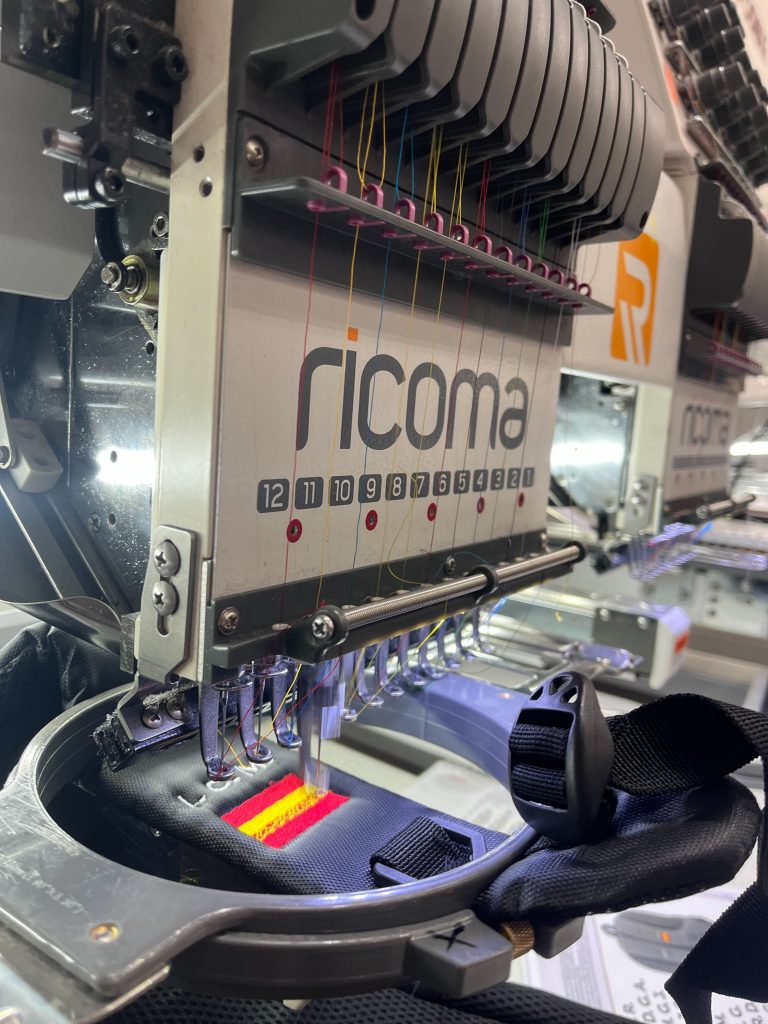 Bordadora cosiendo un producto como técnicas de personalización en regalos promocionales