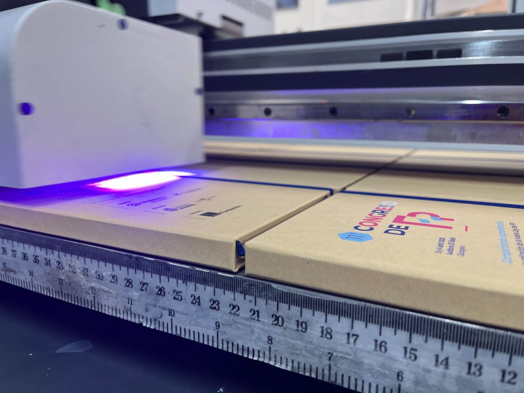 Impresora digital marcando una agenda como técnicas de personalización en regalos promocionales